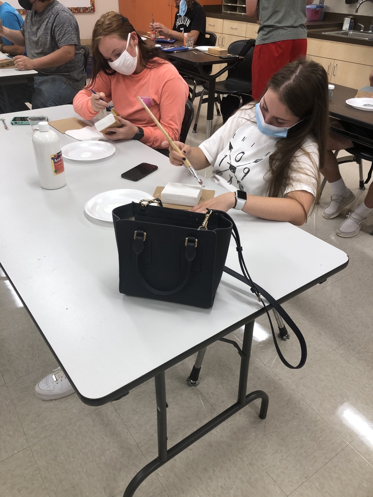 Art students painting their blocks of wood.