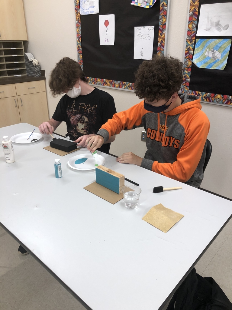 Art students painting their bases for wire sculptures.